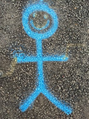 Asfalt yolda boyalı bir gülen adam.