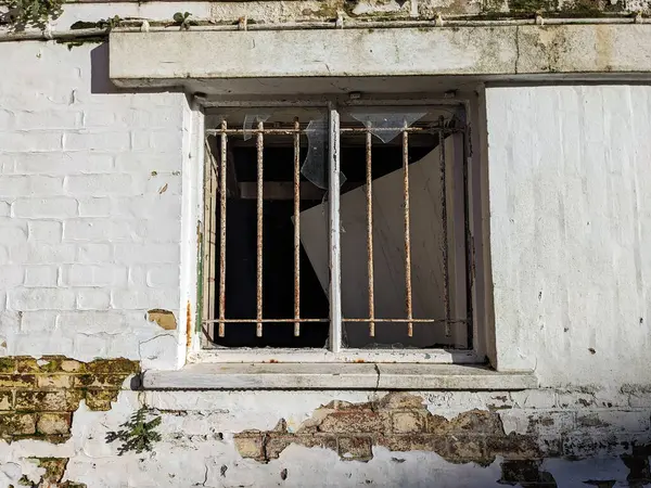 A Smashed Broken Window with Chipped Wall Down an AlleyWay Abandoned Building