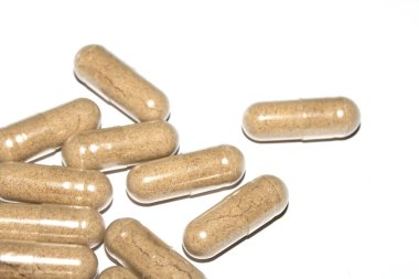 İlaç tedavisi için beyaz zemin üzerinde vitamin kapsülleri ve haplar.
