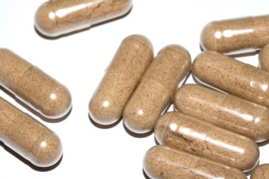 İlaç tedavisi için beyaz zemin üzerinde vitamin kapsülleri ve haplar.