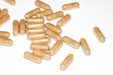 İlaç tedavisi için beyaz zemin üzerinde vitamin kapsülleri ve haplar.