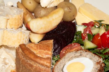 Close Up of a Dinner of Ploughmans Picnic With Pork Pie Scotch Egg Potatoes and Salad clipart