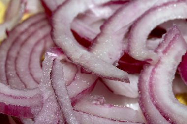 Kesilmiş ve dilimlenmiş kırmızı soğanı ahşap doğrama tahtasına yakın tut.