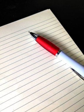 Siyah arkaplan beyin fırtınası çalışmasında satır aralığı kağıdı ve biro kalemini kapat