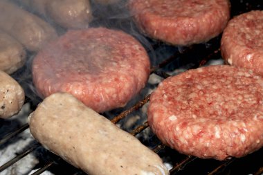 Barbekü burgerlerini ve sosisleri çiğ ızgarada pişmeye hazır et.