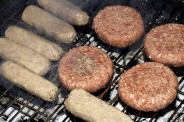 Barbekü burgerlerini ve sosisleri çiğ ızgarada pişmeye hazır et.