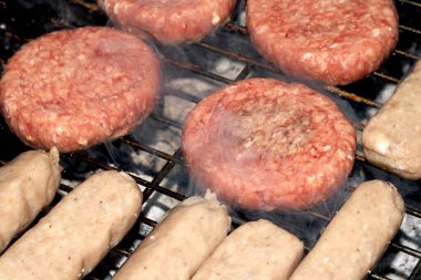 Barbekü burgerlerini ve sosisleri çiğ ızgarada pişmeye hazır et.