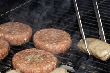 Barbekü burgerlerini ve sosisleri çiğ ızgarada pişmeye hazır et.