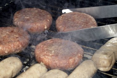 Barbekü burgerlerini ve sosisleri çiğ ızgarada pişmeye hazır et.