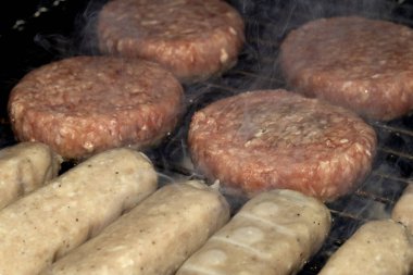 Barbekü burgerlerini ve sosisleri çiğ ızgarada pişmeye hazır et.
