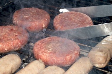 Barbekü burgerlerini ve sosisleri çiğ ızgarada pişmeye hazır et.
