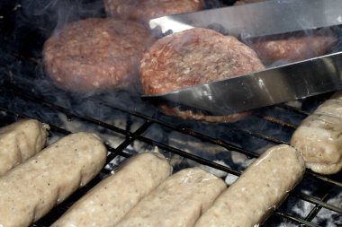 Barbekü burgerlerini ve sosisleri çiğ ızgarada pişmeye hazır et.