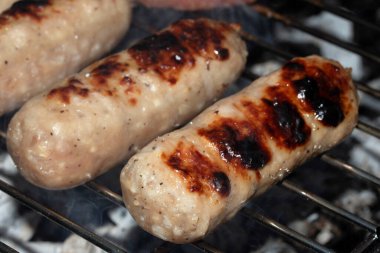 Barbeküye yakın açık hava yemekleri, ızgarada pişmiş sosisli sandviçler.