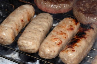 Barbeküye yakın açık hava yemekleri, ızgarada pişmiş sosisli sandviçler.