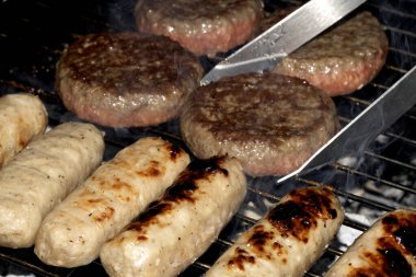 Barbeküye yakın açık hava yemekleri, ızgarada pişmiş sosisli sandviçler.