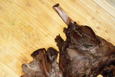 Yavaş pişmiş kuzu eti bacağını ahşap bir tahtanın üzerinde rosto yemeği için kapat.