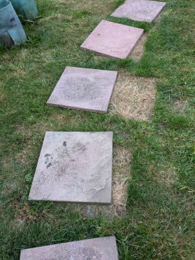 Çimlerin üzerinde veranda fayansları hareket ediyor ve izler bırakıyor