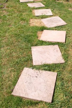 Kırık kaldırım döşemeleri çimlerin üzerinde, bitmesi gerekiyor.