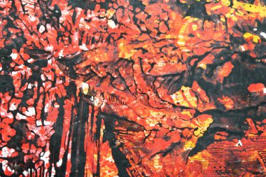 Karalanmış soyut bir arkaplanda koyu kırmızı ve sarı boya.