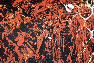 Karalanmış soyut bir arkaplanda koyu kırmızı ve sarı boya.