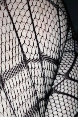 Cilt üzerindeki siyah balık ağı taytlarının kapanışı bacak kıvrımları soyut arkaplan kıvrımları yapar