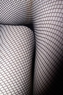 Cilt üzerindeki siyah balık ağı taytlarını kapat. Bacaklar soyut arkaplan kıvrımları yapar.