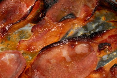 Alüminyum folyoda az pişmiş domuz pastırması şeritlerini yakın.