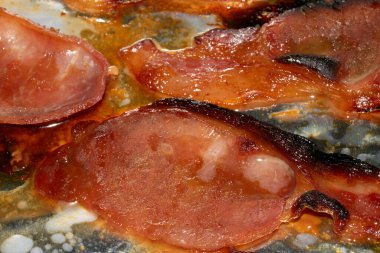 Alüminyum folyoda az pişmiş domuz pastırması şeritlerini yakın.