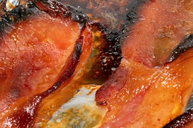 Alüminyum folyoda az pişmiş domuz pastırması şeritlerini yakın.