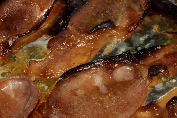 Alüminyum folyoda az pişmiş domuz pastırması şeritlerini yakın.