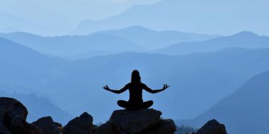 Yoga yapan genç bir kadının silueti.