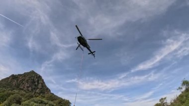 Helikopter dağlık arazide kargo teslim ediyor. Yüksek kalite 4K görüntü. ses ile video