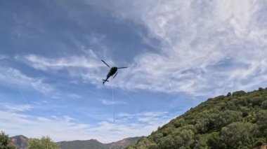 Helikopter dağlık arazide kargo teslim ediyor. Yüksek kalite 4K görüntü. ses ile video