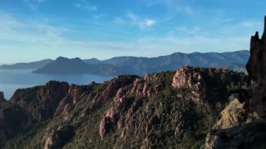 Fransa, Korsika 'da, Akdeniz yakınlarında sakin bir göle bakan bir dağ sırasının nefes kesici manzarasına dikkatle bakın. Calanques de Piana sihirli bir doğa manzarası sunuyor..