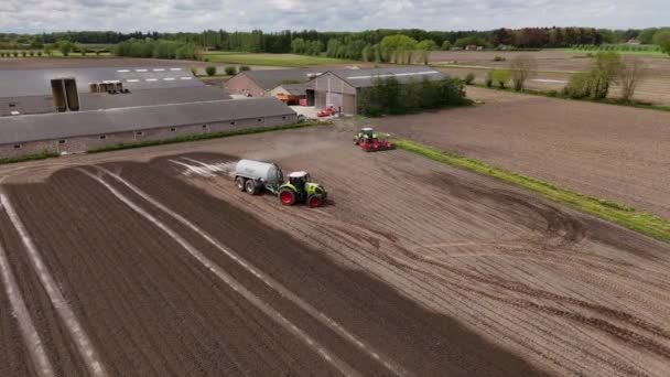 田里耕作和施肥的拖拉机和拖车 在农场上起作用 图库视频