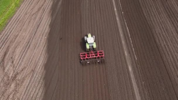 트랙터가 일광에 들판을 흐르면서 농업을위한 토양을 전환하고 수정하는 보십시오 — 비디오
