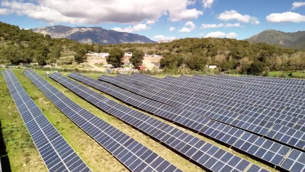 科西嘉岛上一排排以山脉为背景的太阳能电池板 产生绿色能源 视频剪辑