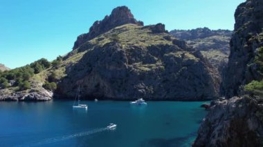 Sa Calobra, Palma de Mallorca 'da huzur içinde yüzen bir grup tekneyi izleyin..