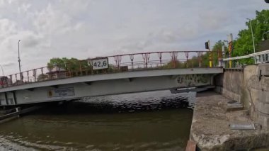 Bruges, Belçika 'da bir kanalın üzerinde açılan ve kapanan köprüyü izleyin. Güneşli bir günde su trafiğinin geçmesine olanak sağlıyor..
