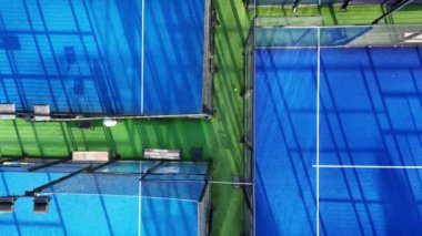 İki tenis kortunun yüksek açılı görüntüsü, boş ve oynamaya hazır..