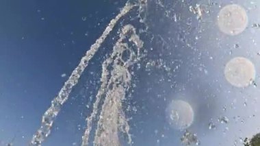 Gökyüzünde çağlayan su damlacıklarının büyüleyici görüntüsü, öğleden sonra güneşiyle aydınlatılır, uzaktaki ayı bir anlığına görür..