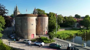 Bruges, Belçika 'daki eski bir taş kapının resimli görüntüsü. Kapı bir kanalın üzerinde duruyor, zengin şehir tarihini gözler önüne seriyor..