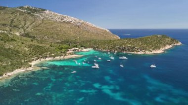 Sardinya 'da sakin bir koy, turkuaz suda sallanan kayıklar. Çevresindeki manzara yemyeşil ve yemyeşil. Resmedilmeye değer bir manzara oluşturuyor..