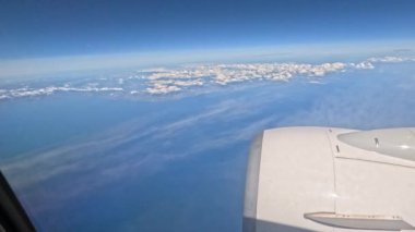 Sardunya 'ya inerken bulutların ve kıyı şeridinin uçak görüntüsü.