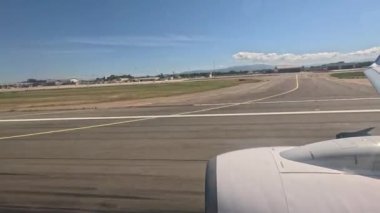 Sardinya 'ya inen uçak, yolcu penceresinden görülüyor. Pist ve çevresindeki havaalanı görülebilir..