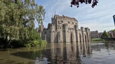 Gent, Belçika 'daki Gravensteen Kalesi' nin su ve yemyeşil bir manzarası..