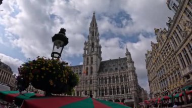 Bulutlu bir günde Brüksel 'deki Grand Place, Belediye Binası' nın ve çevresindeki binaların karmaşık mimarisini gözler önüne seriyor..