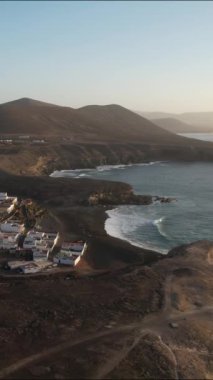 Güneş batarken Fuerteventura 'nın çarpıcı sahil şeridini keşfedin. Pahalı manzaraya ve deniz kenarındaki büyüleyici köye sıcak bir ışıltı saçın..