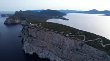 Güneş batarken Capo Caccia 'nın çarpıcı sahil kayalıklarına ve sakin sularına tanık olun. Gökyüzünü canlı renklerle ve huzurlu yansımalarla boyayın..