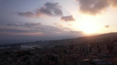 Güneş batarken Ceneviz siluetinin çarpıcı dönüşümüne tanık olun. Şehir ve liman üzerinde canlı renkler oluşturarak büyüleyici bir atmosfer yaratıyor..